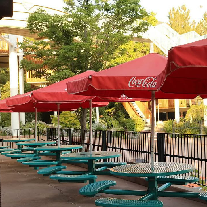 Tables with umbrellas sitting near the food stands at Lagoon-A-Beach