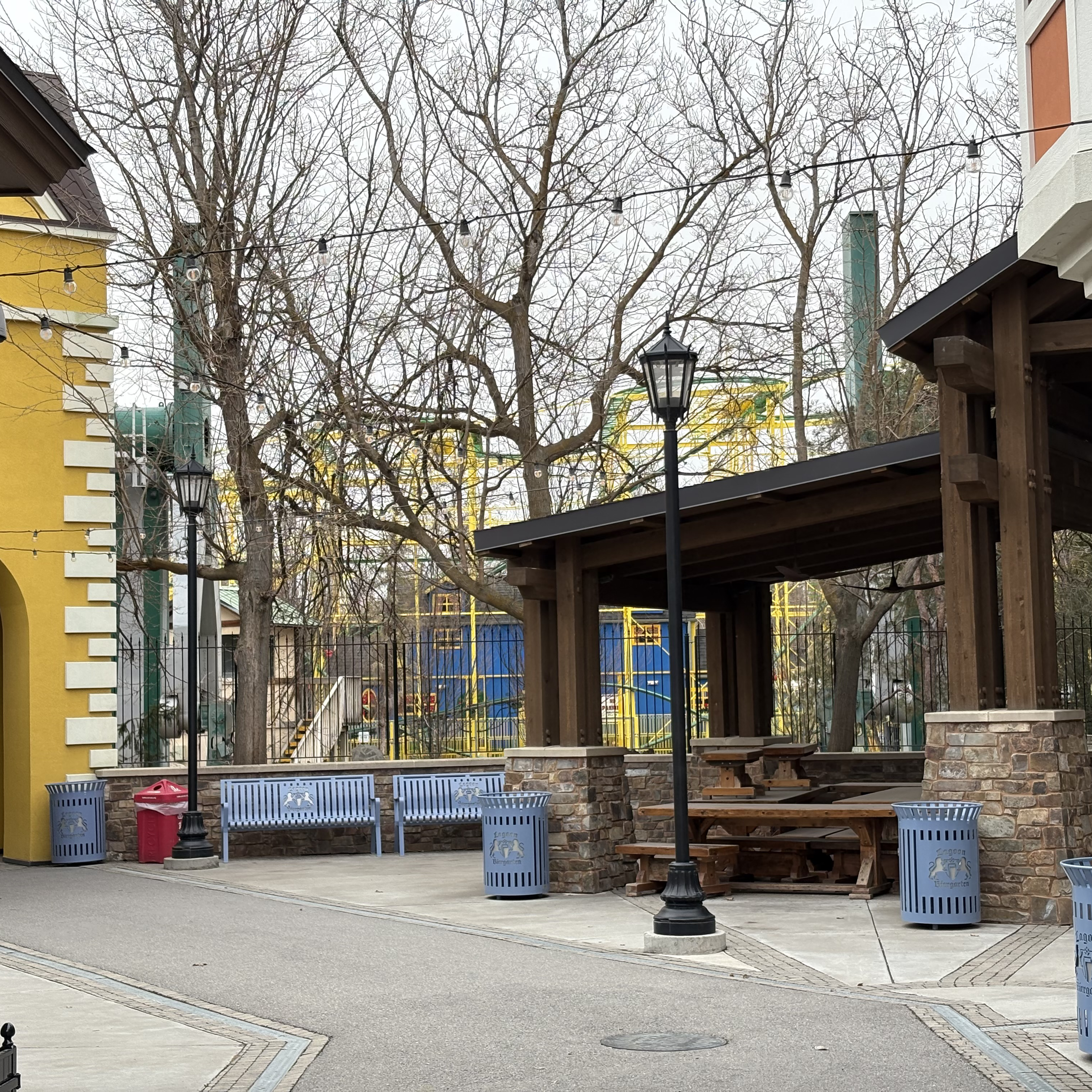 A picture of Cliffhanger at Lagoon a few weeks before park opening. The image is taken from the entrance to the Biergarten, and you can see the ride through trees.